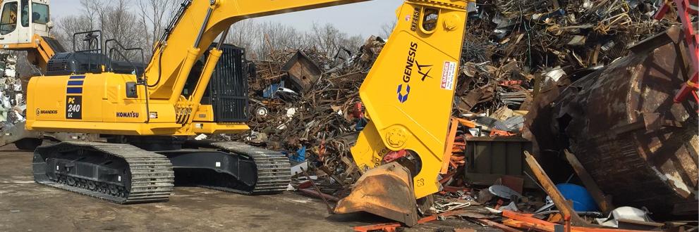 Yellow GXT grabbing steel in front of a scrap pile