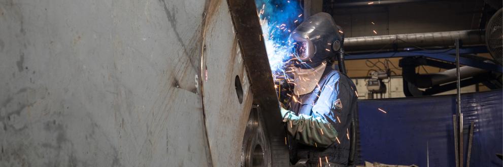 Welder welding on an attachment