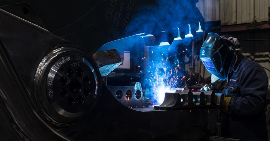 Employee welding an attachment